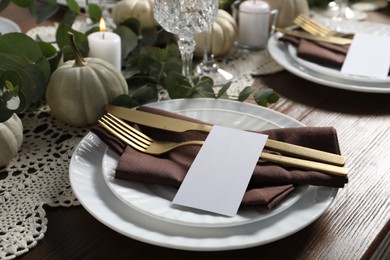 Photo of Beautiful autumn table setting. Plates, cutlery, blank cards and floral decor