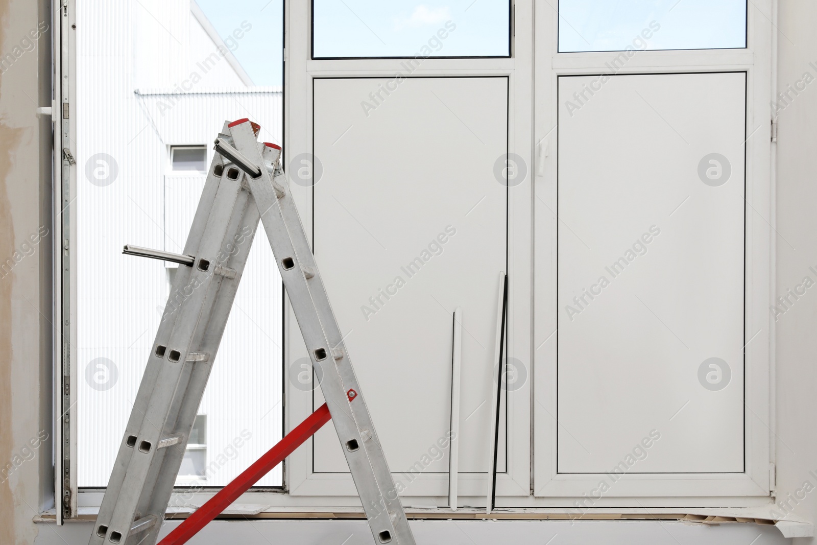 Photo of Folding ladder near open window indoors. Double glazing installation