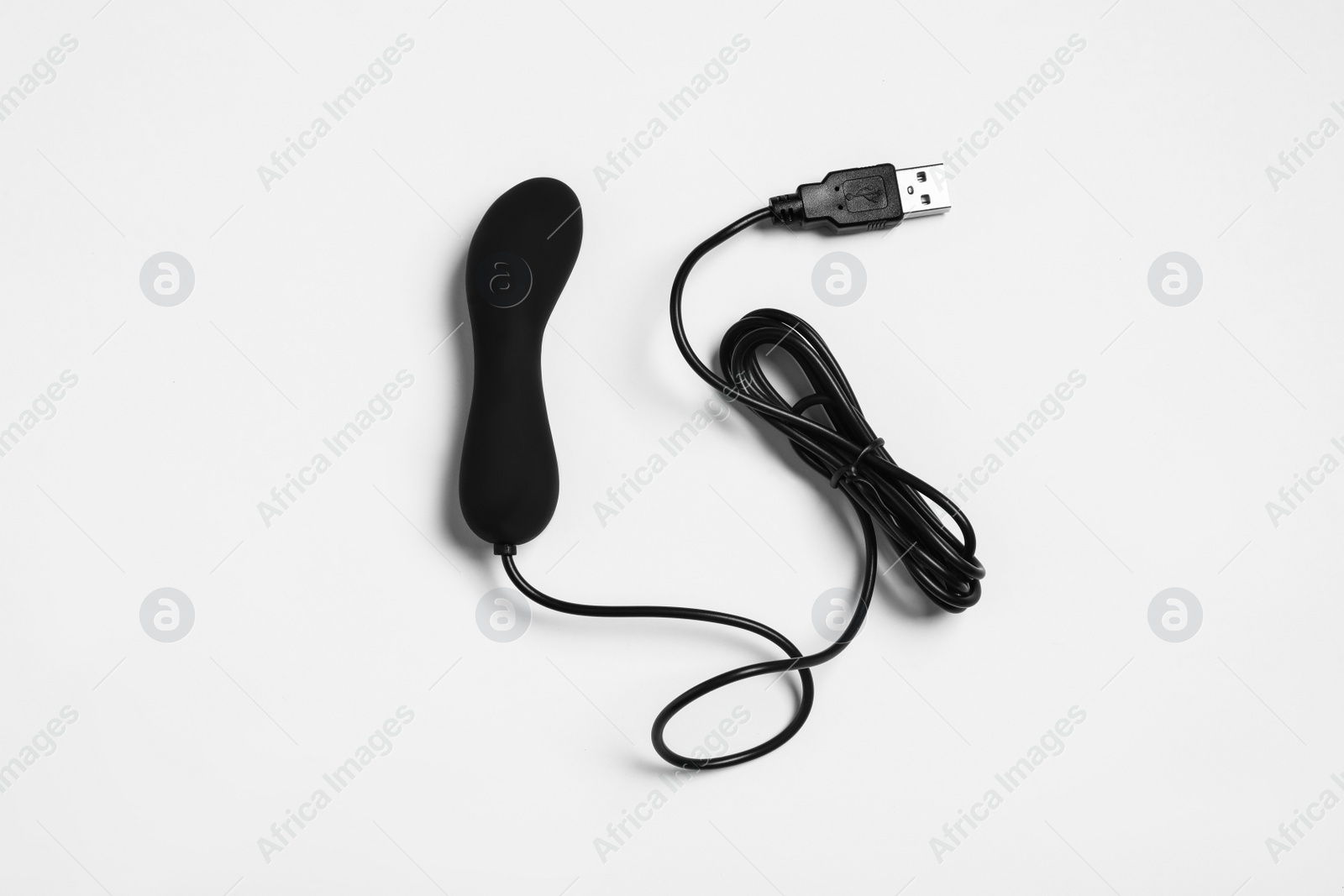 Photo of Black vibrator on white background, top view. Sex toy