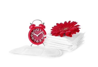 Menstrual pads, alarm clock and flower on white background. Gynecological care