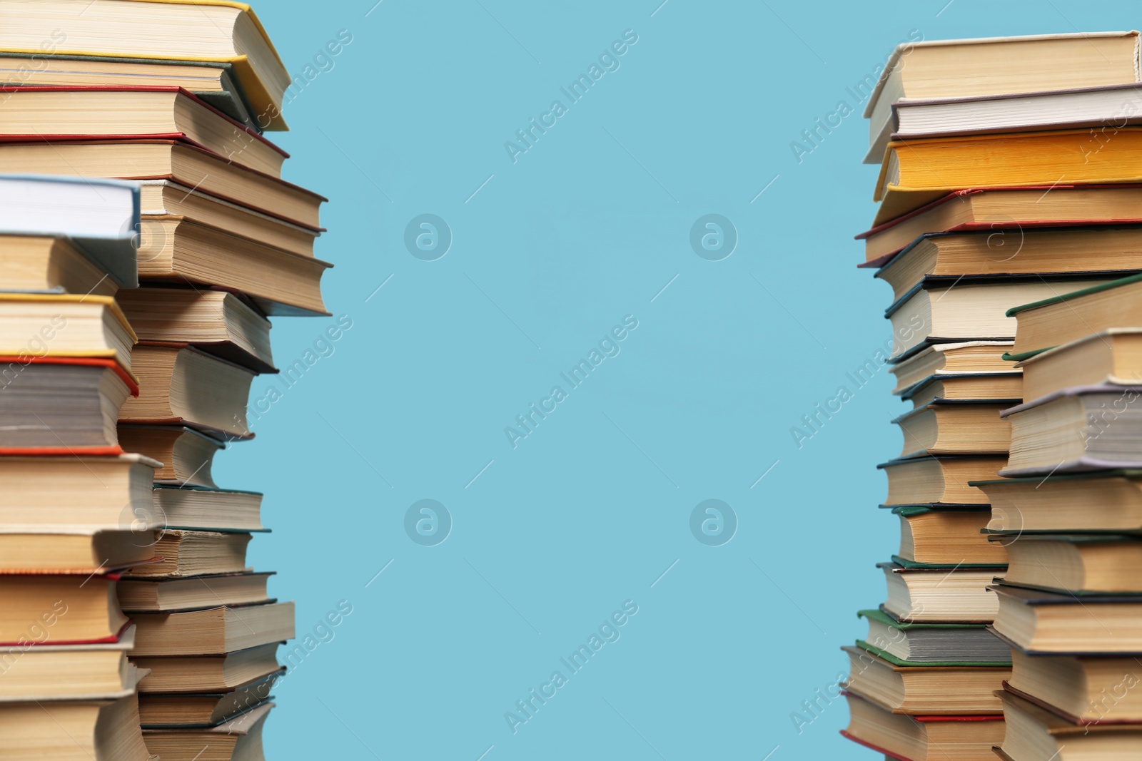 Photo of Many hardcover books on turquoise background, space for text. Library material