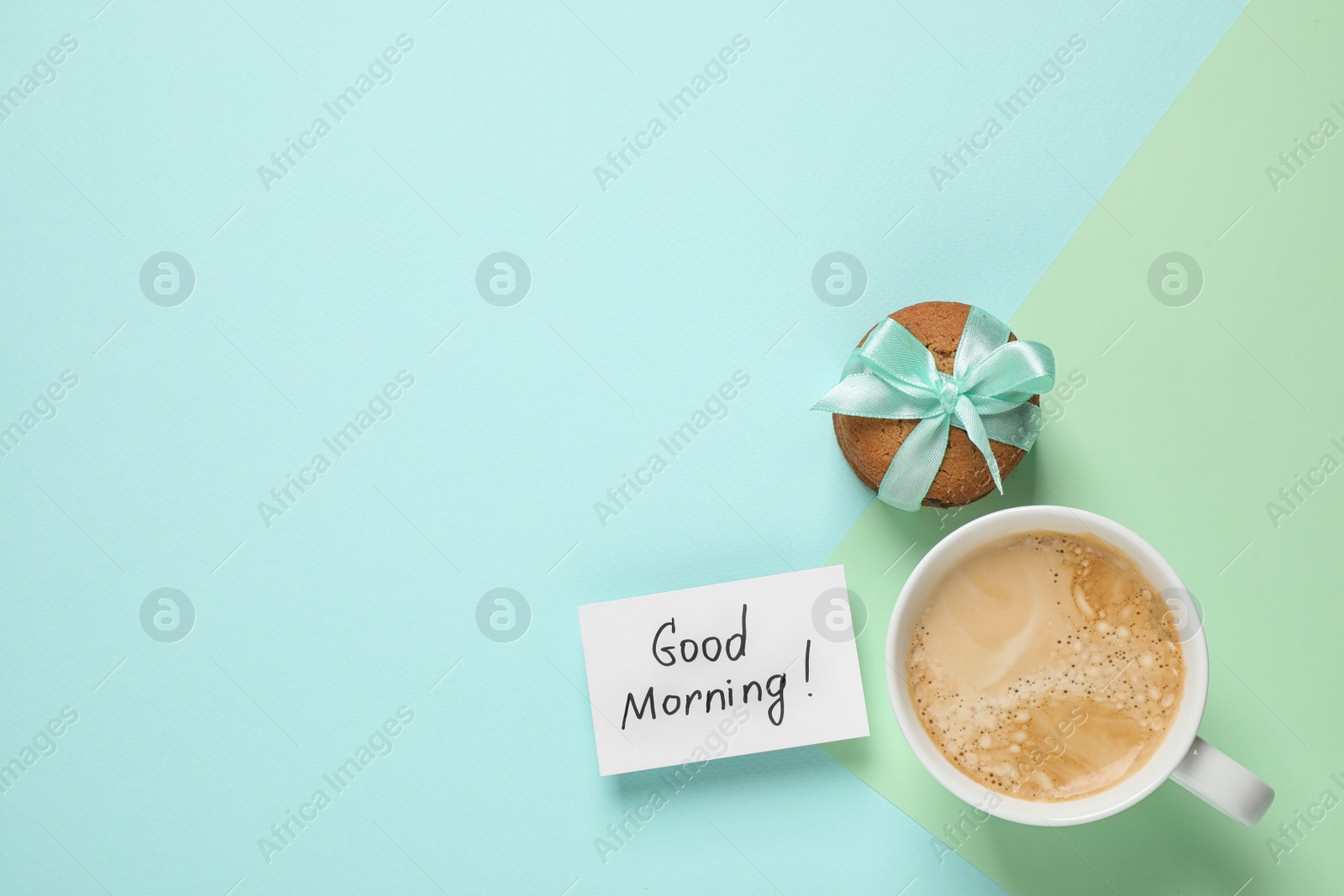 Photo of Message GOOD MORNING, cookie and coffee on color background, flat lay. Space for text