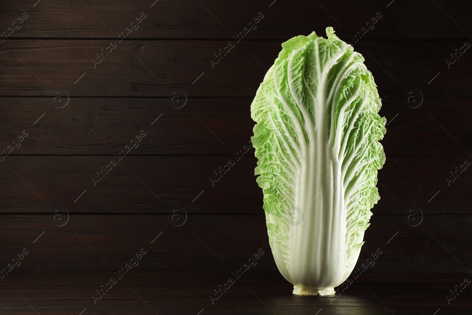 Photo of Fresh ripe Chinese cabbage on table against wooden background. Space for text