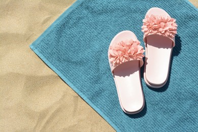 Towel and flip flops on sand, top view. Beach accessories