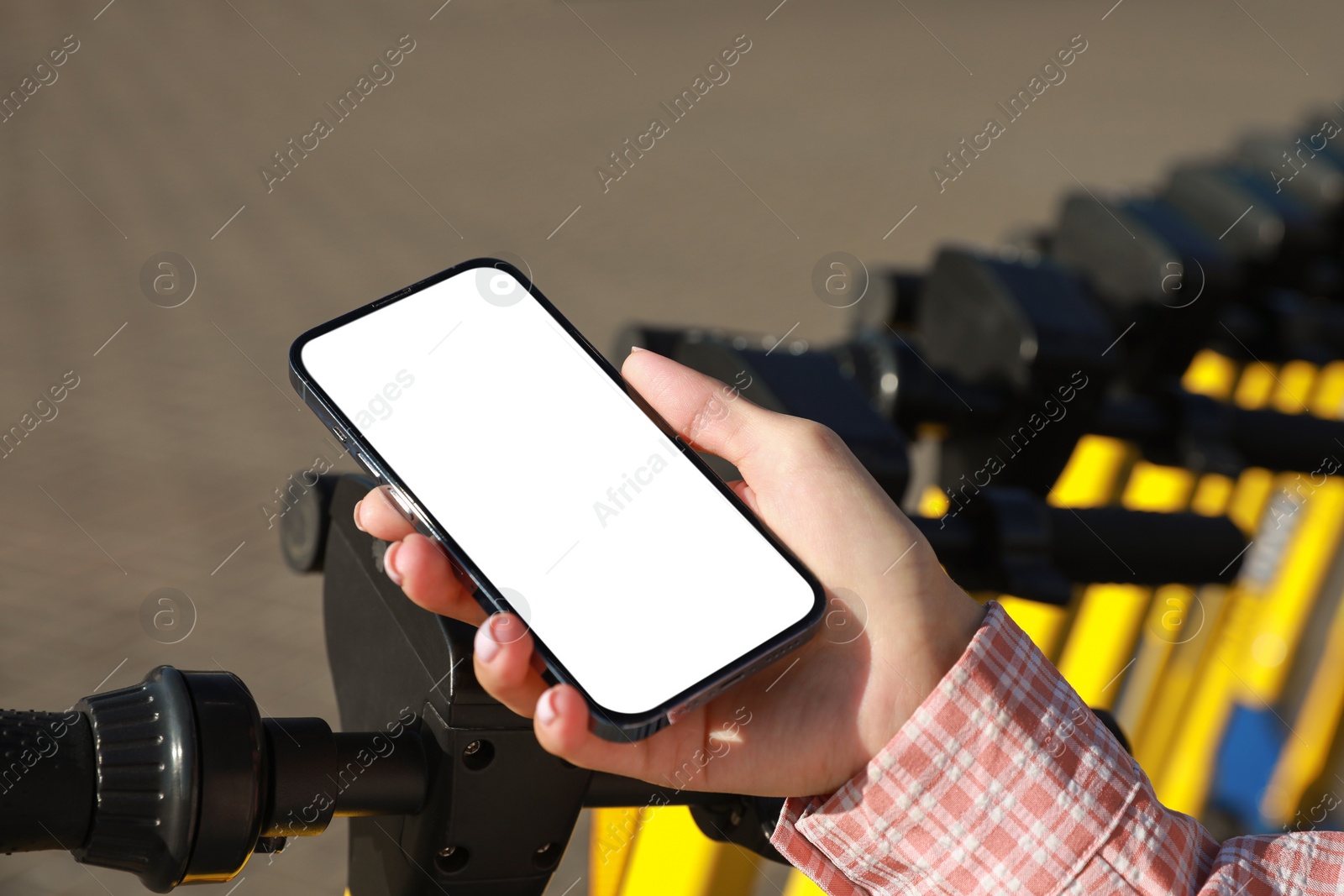 Photo of Woman using smartphone to pay and unblock electric kick scooter outdoors, closeup