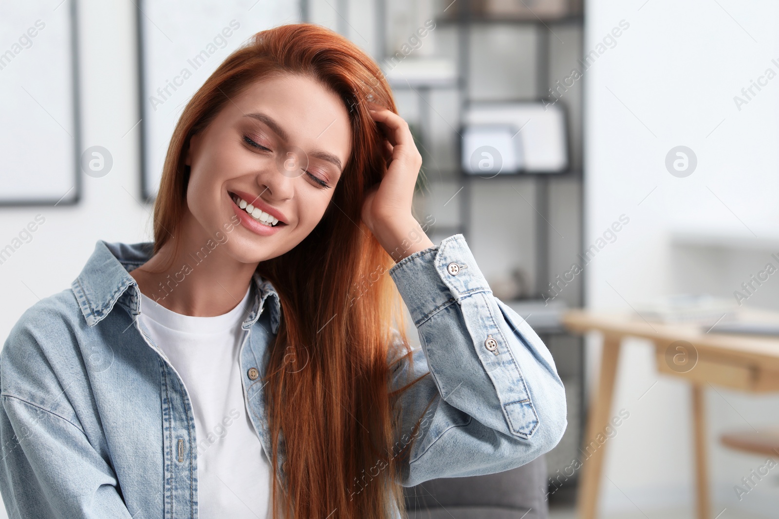 Photo of Portrait of beautiful smiling young woman. Happy lady with red hair at home. Space for text