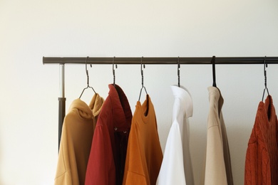 Photo of Rack with stylish clothes indoors, closeup. Interior design