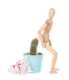 Wooden human figure, cactus and sheets of toilet paper with blood on white background. Hemorrhoid problems