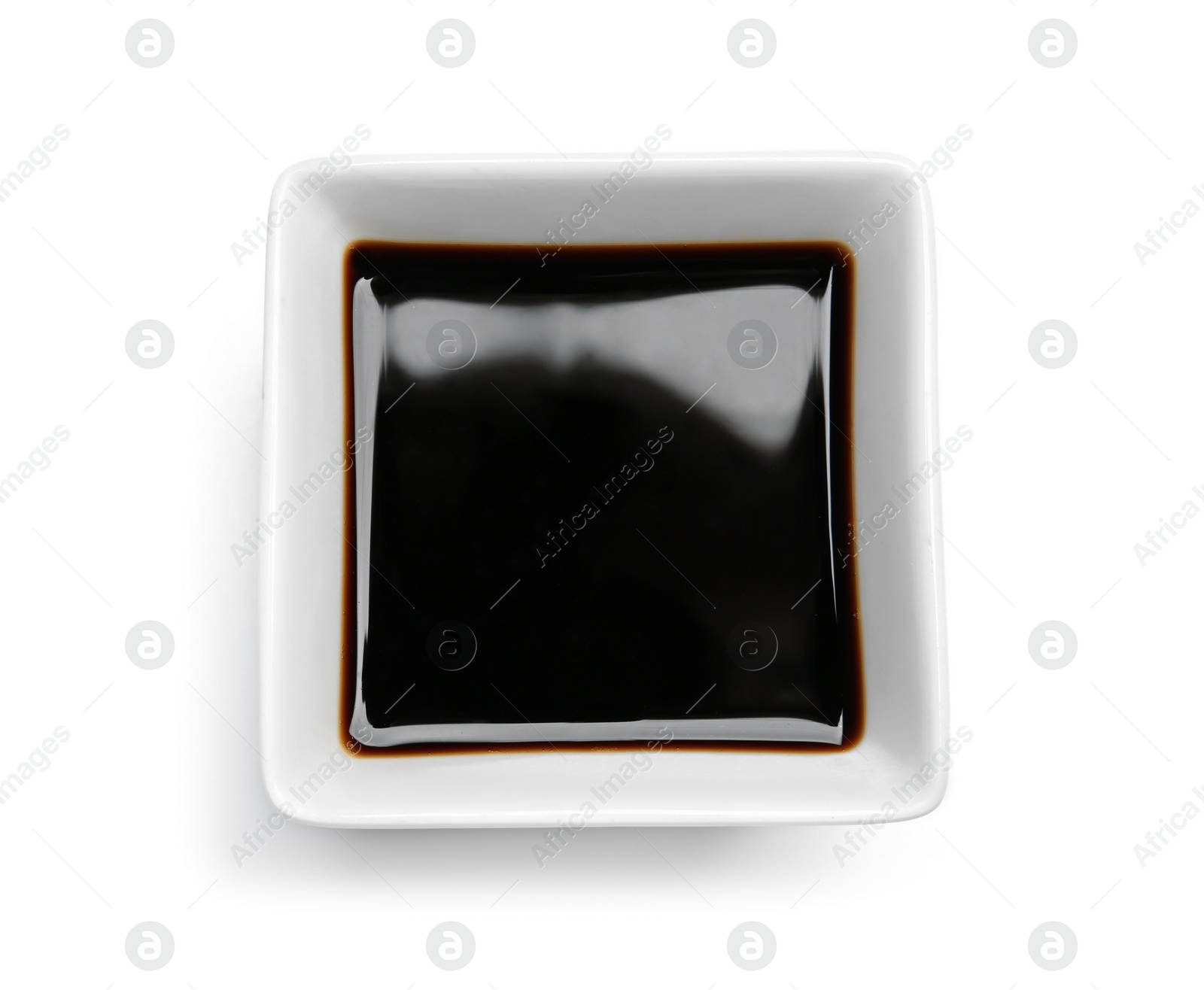 Photo of Dish of soy sauce on white background, top view