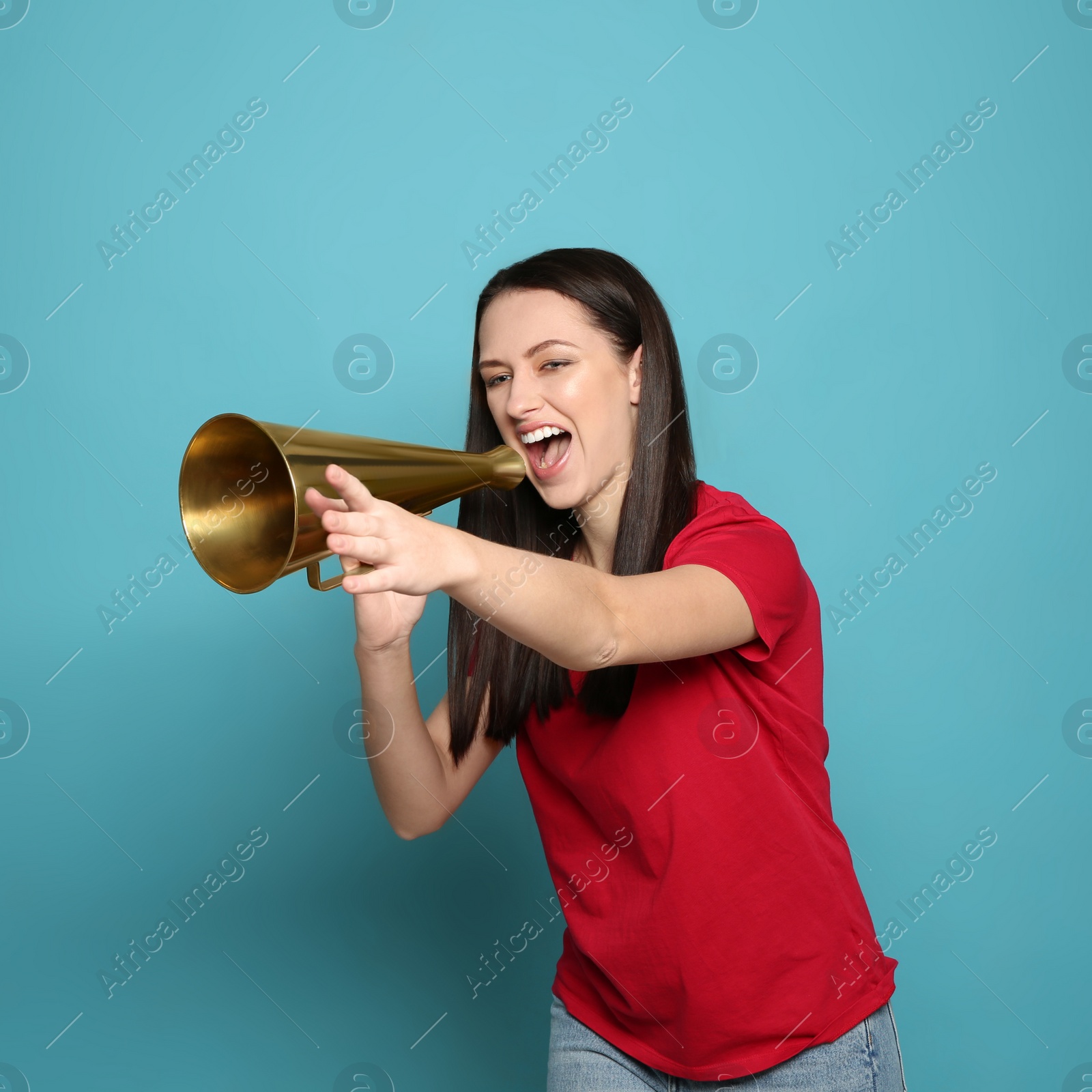 Photo of Emotional young woman with megaphone on color background
