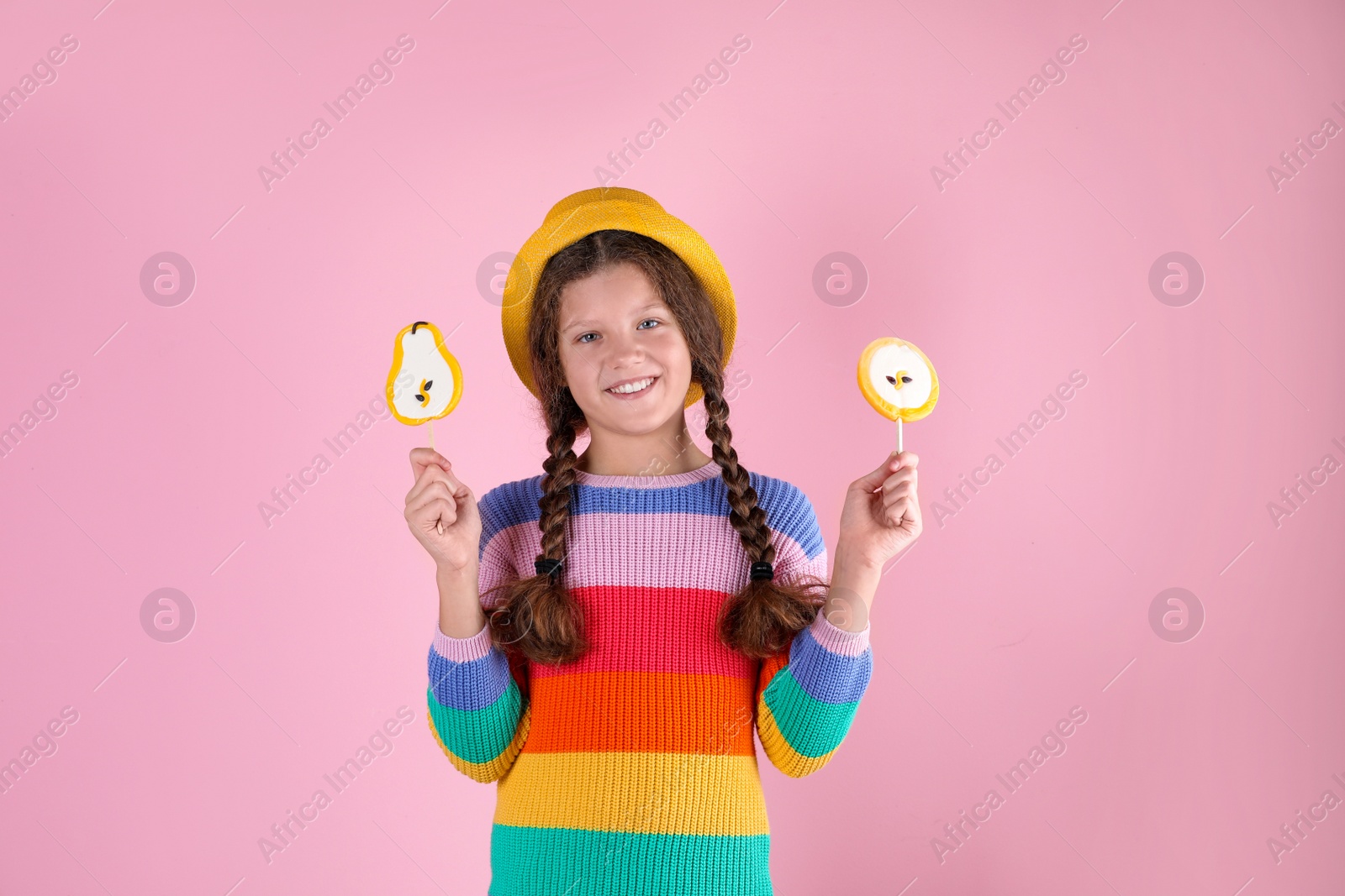 Photo of Little girl with candies on color background