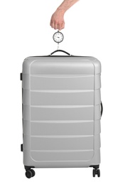 Man weighing stylish suitcase on white background