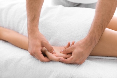 Photo of Young woman receiving massage in salon, closeup