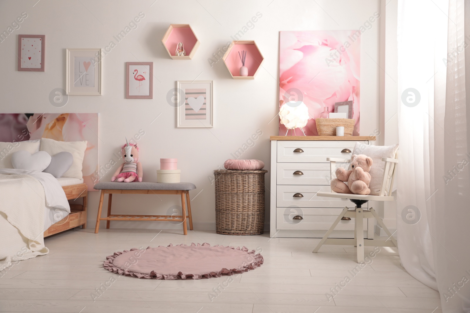 Photo of Stylish child's room interior with beautiful pictures and comfortable bed