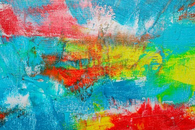 Photo of Strokes of colorful acrylic paints on canvas, closeup