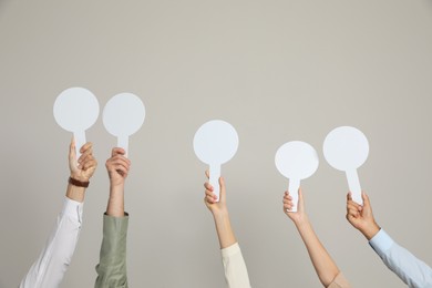 Photo of Panel of judges holding blank score signs on beige background, closeup. Space for text