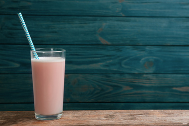 Protein shake on wooden table, space for text