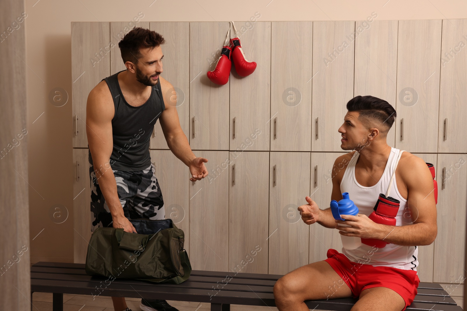 Photo of Handsome athletic men talking in locker room