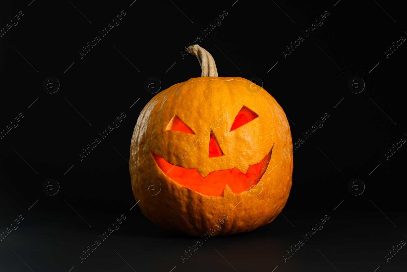 Photo of Pumpkin head on black background. Jack lantern - traditional Halloween decor