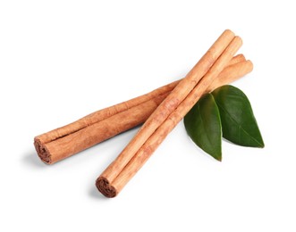 Photo of Cinnamon sticks and green leaves isolated on white