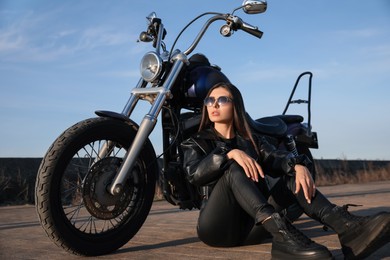 Photo of Beautiful woman sitting near motorcycle on sunny day