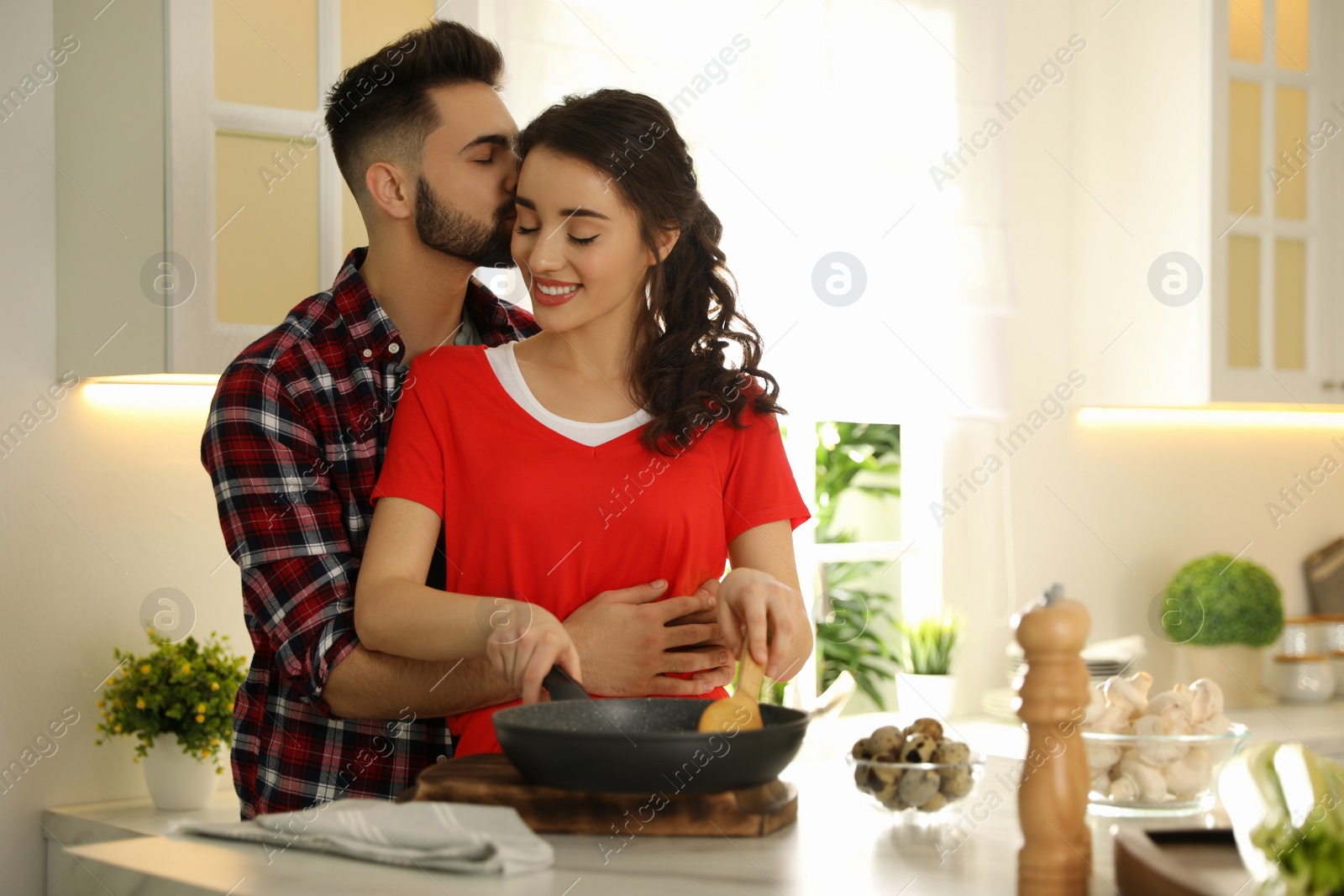 Photo of Lovely young couple cooking together in kitchen