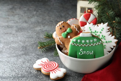 Photo of Delicious Christmas cookies in bowl on grey table. Space for text