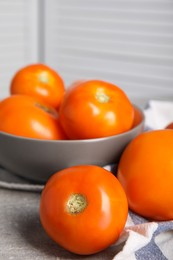 Photo of Many ripe yellow tomatoes on grey table, closeup