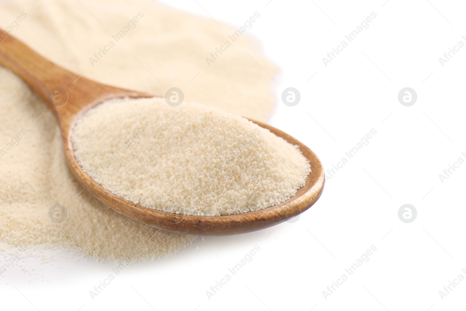 Photo of Spoon and organic semolina on white background, closeup