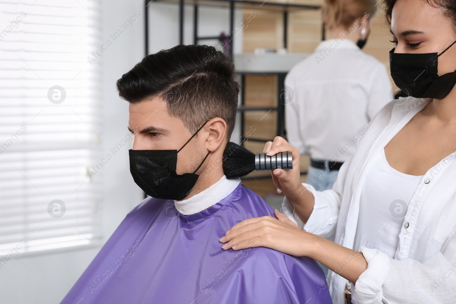 Photo of Professional stylist working with client in salon. Hairdressing services during Coronavirus quarantine