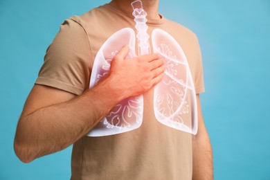 Man holding hand near chest with illustration of lungs on turquoise background, closeup