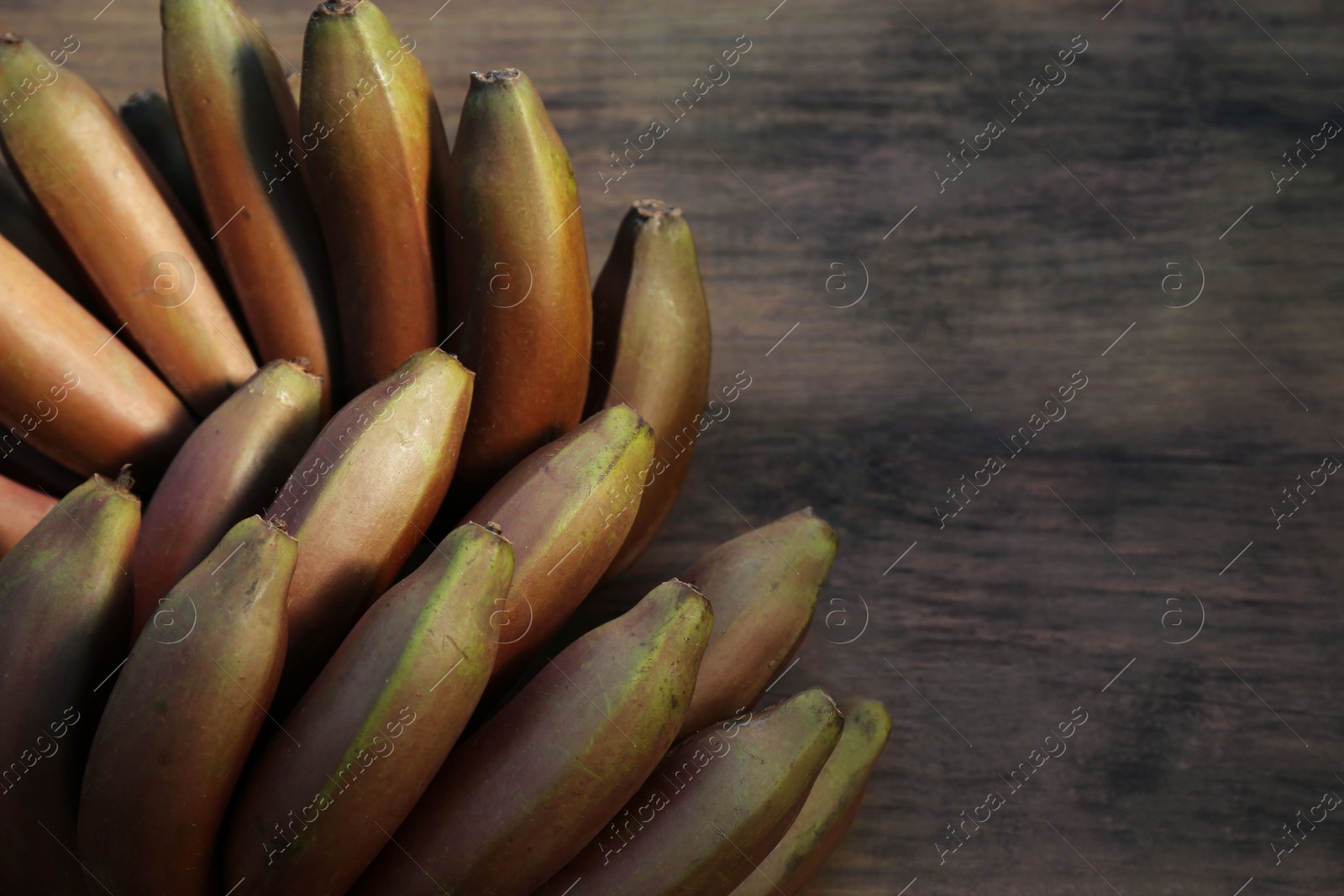 Photo of Tasty purple bananas on wooden table, top view. Space for text