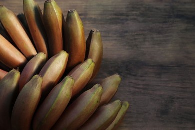 Photo of Tasty purple bananas on wooden table, top view. Space for text