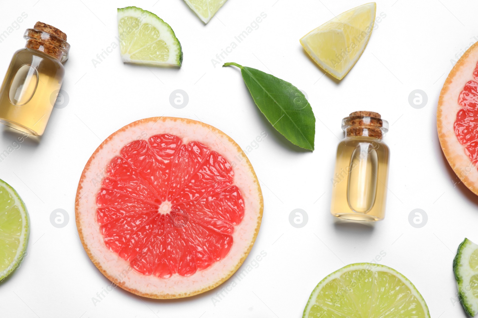 Photo of Flat lay composition with bottles of citrus essential oil on white background