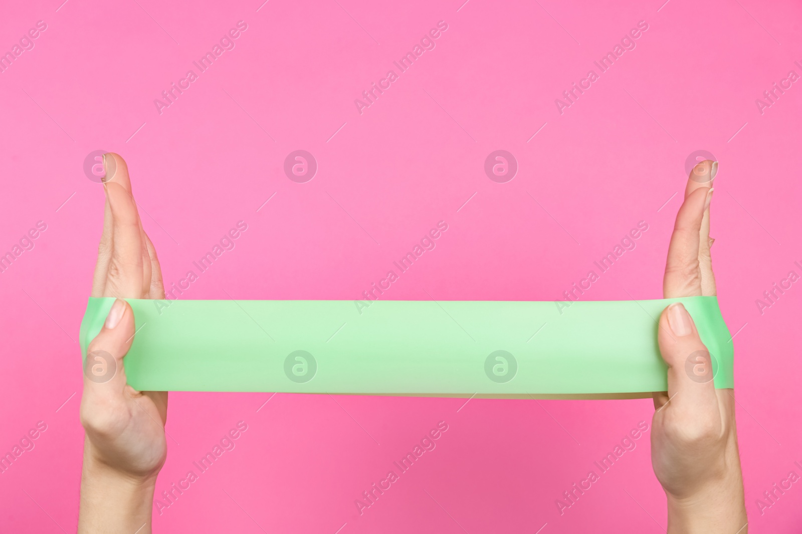 Photo of Woman with fitness elastic band on pink background, closeup