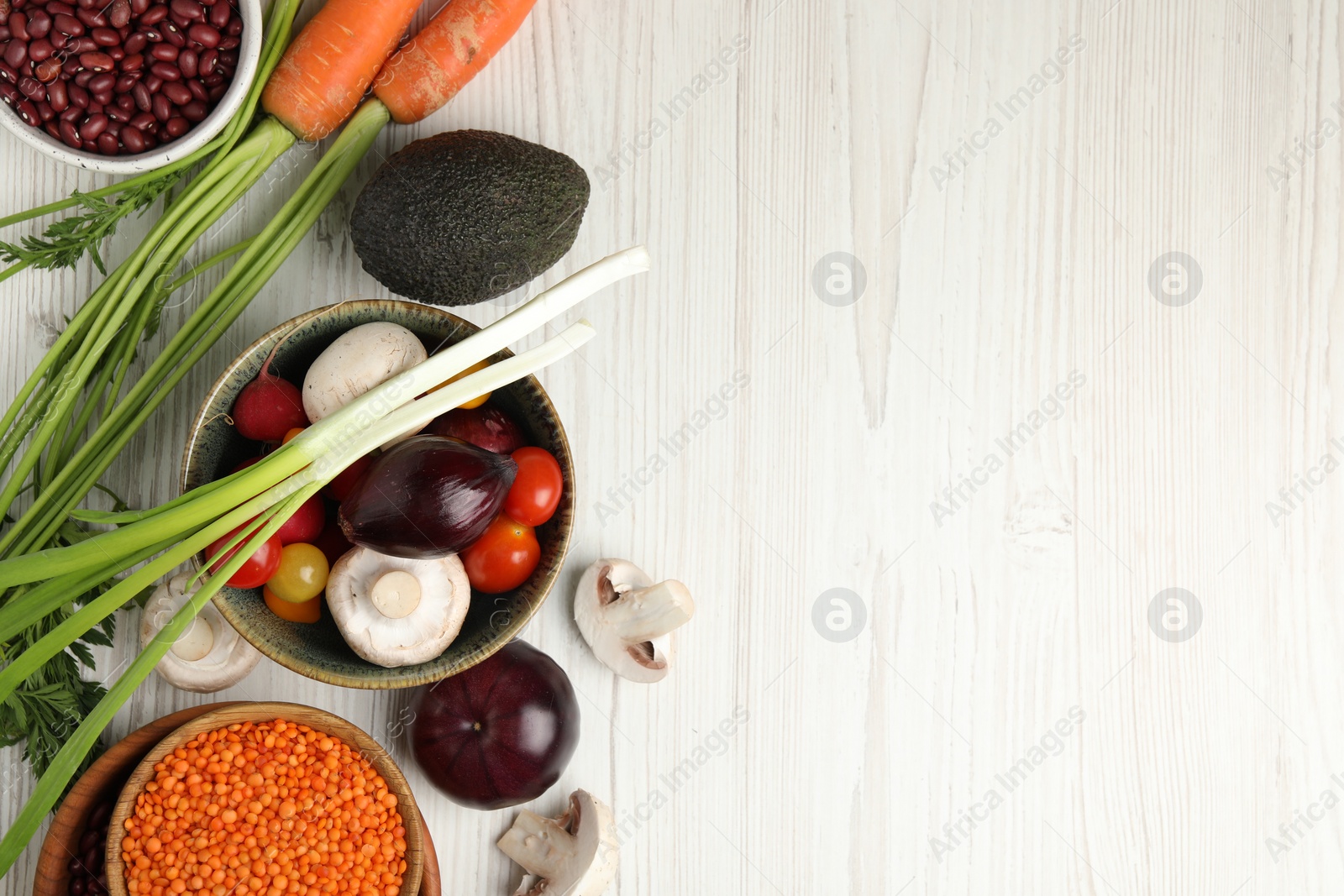 Photo of Different vegetables on white wooden table, flat lay and space for text. Vegan diet