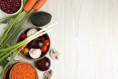 Different vegetables on white wooden table, flat lay and space for text. Vegan diet