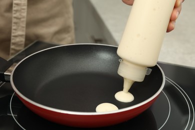Photo of Woman cooking cereal pancake on stove, closeup