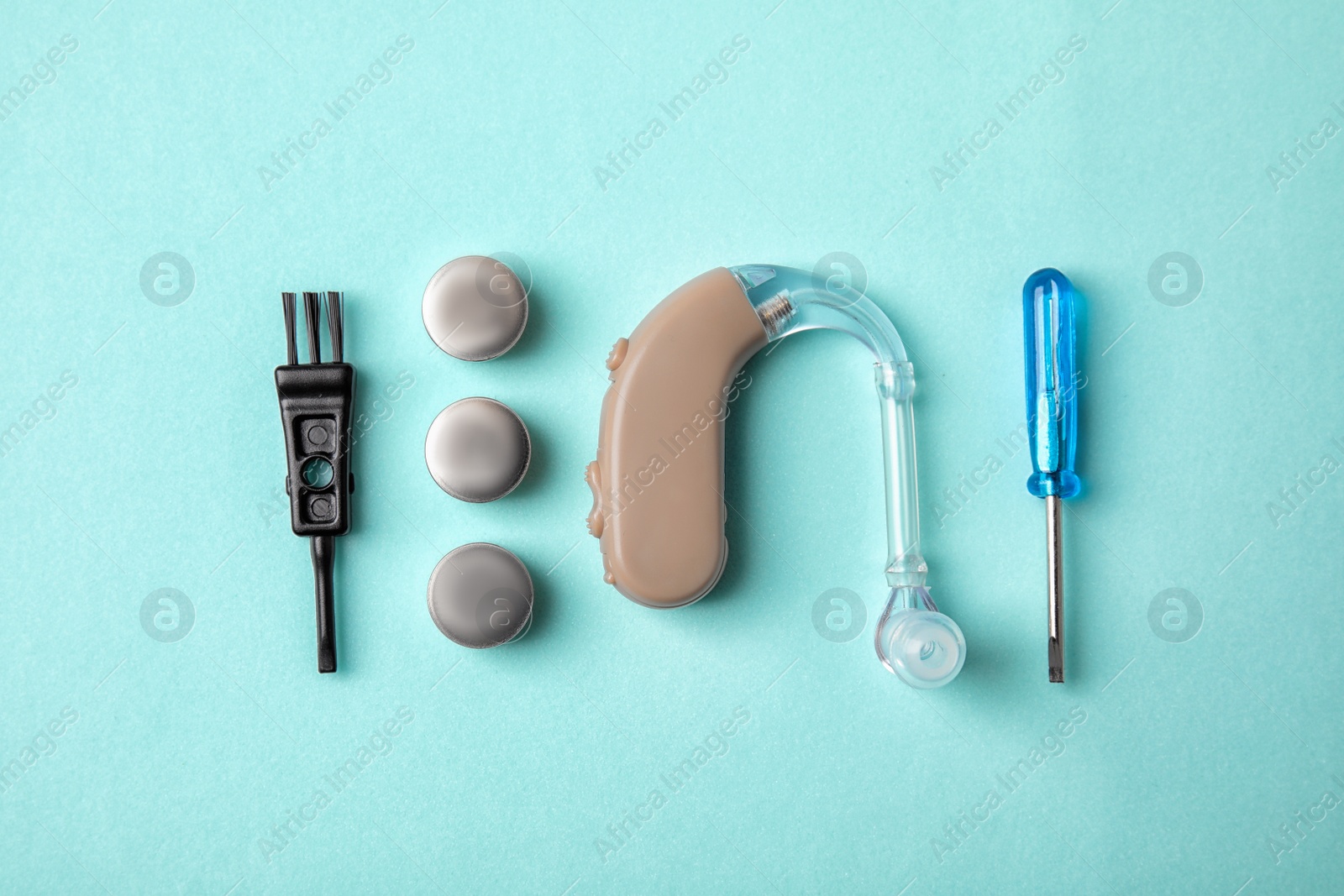 Photo of Flat lay composition with hearing aid and accessories on color background