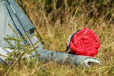 Sleeping bag and mat near camping tent outdoors