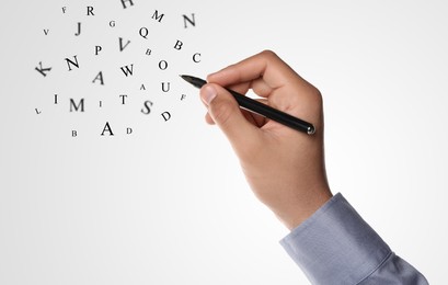 Image of Man writing letters and they flying away on grey gradient background, closeup