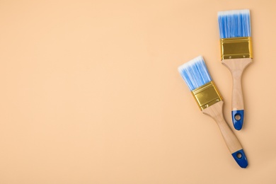 Photo of Paint brushes on color background, top view. Space for text