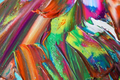Photo of Strokes of colorful acrylic paints as background, closeup view