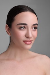 Photo of Portrait of beautiful young woman on grey background