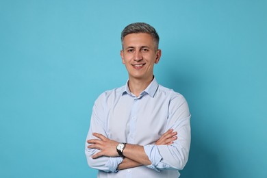 Portrait of happy man on light blue background