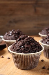 Photo of Tasty chocolate muffin on wooden board, closeup