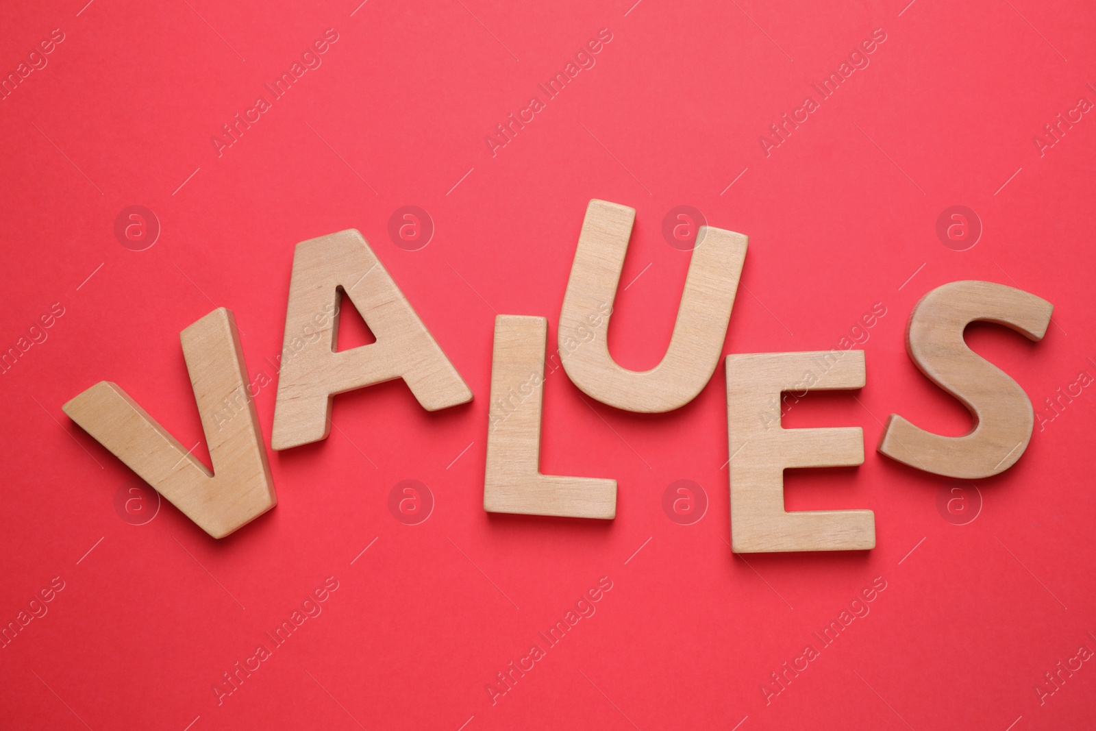Photo of Word VALUES made of wooden letters on red background, flat lay