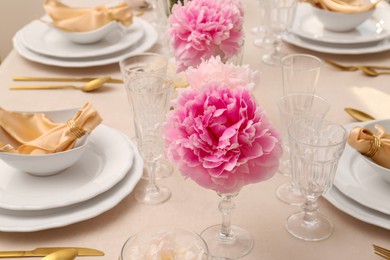 Photo of Stylish table setting with beautiful peonies and fabric napkin, closeup