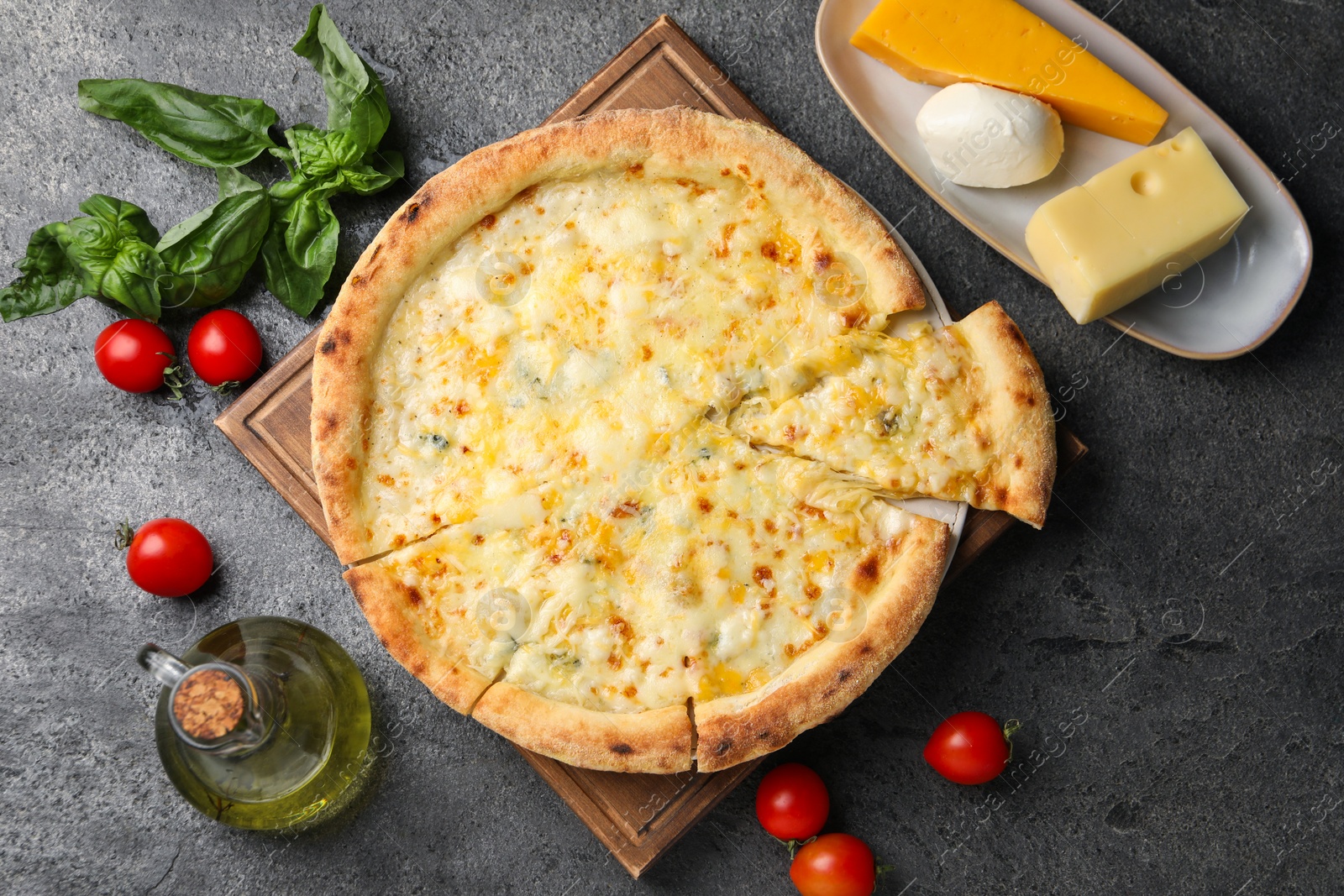 Photo of Delicious cheese pizza and ingredients on dark grey table, flat lay