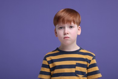 Photo of Portrait of sad little boy on purple background, space for text